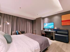 库尔勒巴州库尔勒市金都广场兰欧酒店的一间卧室配有一张床、一张书桌和一台电视