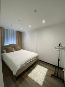新帕扎尔Glass Apartmani的卧室配有白色的床和白色地毯。