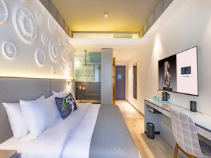 桂林兰欧酒店桂林万福广场的卧室配有一张白色大床和电视。