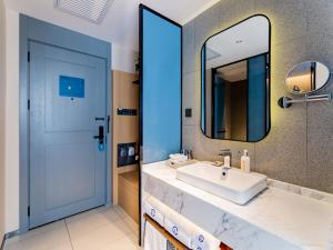 呼和浩特呼和浩特新城区摩尔城兰欧尚品酒店的浴室设有白色水槽和镜子
