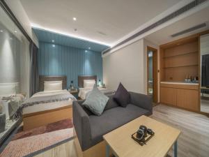 广州希诺酒店·广州北京路省人民医院店的一间卧室配有一张床、一张沙发和一张桌子