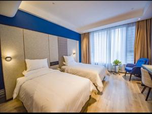 菏泽菏泽牡丹区大学城兰欧酒店的酒店客房设有两张床和蓝色的墙壁。