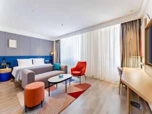 呼和浩特呼和浩特新城区摩尔城兰欧尚品酒店的酒店客房,配有一张床和一张红色椅子