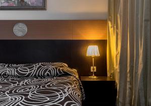 圣彼得堡斯普妮可酒店的一间卧室配有一张床和一张桌子上的台灯