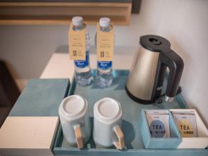 广州希诺酒店·广州北京路省人民医院店的一张桌子、茶壶和两瓶水