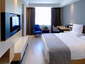 格尔木兰欧酒店格尔木八一中路的酒店客房设有一张床、一张书桌和一台电视机。
