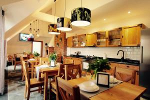 拉布卡KOŃSKA GÓRKA Agroturystyka的厨房以及带木桌和椅子的用餐室。