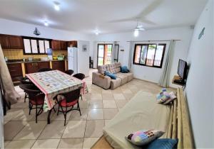 伊塔波阿Casa Conforto! A sua casa de praia em Itapoá - SC的厨房以及带桌子和沙发的客厅。