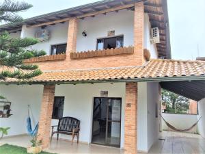 伊塔波阿Casa Conforto! A sua casa de praia em Itapoá - SC的带阳台和椅子的房子