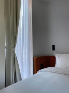 清迈The Sayla hotel(Baan Sayla)的卧室配有白色的床和窗户。