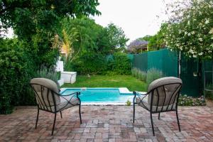 格拉夫-里内特Garden House的两把椅子坐在游泳池前