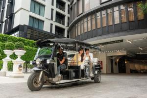 曼谷The Quartier Hotel Phromphong - Thonglor by Compass Hospitality的一群人乘坐高尔夫球车