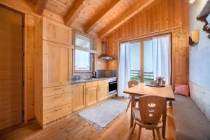 斯卢德尔诺Grushof App Köpfl的厨房配有木制橱柜和桌椅