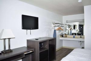 弗雷德里克斯堡弗雷德里克斯堡速8汽车旅馆的一间房间,配有一张床和墙上的电视