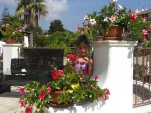 利帕里博尔戈伊欧利酒店的站在一些盆栽植物旁的小女孩