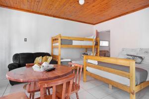派恩敦25 Jacaranda Lodge & Backpackers的客厅配有桌子和双层床。