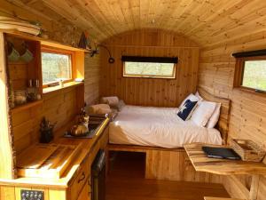 多切斯特Orchard retreat off grid shepherds huts in Dorset的小木屋内的小卧室配有床