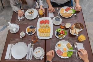 撒马尔罕Marokand Spa Hotel的一群坐在餐桌上的人,他们吃着早餐