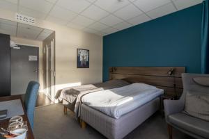 于默奥Hotell Entré Norr的一间卧室设有一张床和蓝色的墙壁