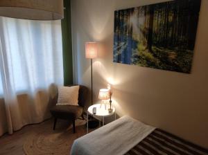 Gîte La Renéade的一间卧室配有一张床、一把椅子和一盏灯
