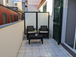 丰沙尔Tanoeiros Studios的阳台配有2把椅子和1张桌子
