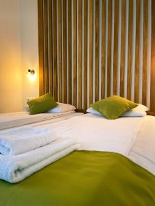 雷梅齐乡Pensiunea AN de AN Remeti的一张带绿色枕头的大型白色床