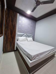 戈勒克布尔Hotel Shanti Grand Inn的一间卧室配有一张大床和白色床单