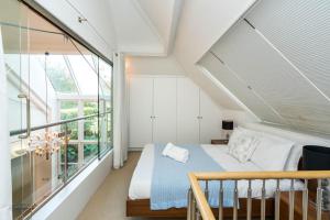 伦敦Unique 2 Bedroom converted Artists Studio的一间卧室设有一张床和一个大窗户
