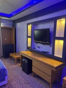 GaziemirÜnaten otel的墙上配有平面电视的房间