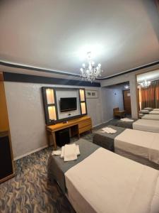 GaziemirÜnaten otel的一间酒店客房,设有三张床和一台平面电视