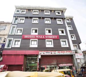 新德里Hotel Wall Street的上面有酒店墙街标志的酒店大楼