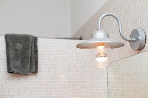 巴塞罗那阿普图卡特公寓的浴室里的光线,墙上有毛巾