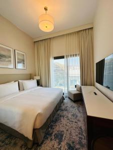 富查伊拉Ocean Mountain View Apartment at The Address Fujairah的一间酒店客房,设有一张大床和一个大窗户