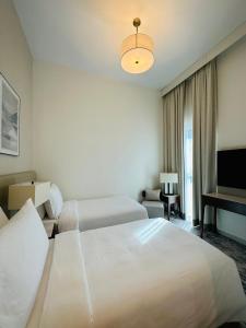 富查伊拉Ocean Mountain View Apartment at The Address Fujairah的酒店客房设有两张床和电视。