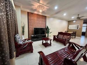 LunasGrand Homestay Kulim 4-Bedroom的客厅配有木制家具和电视