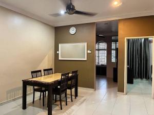 LunasGrand Homestay Kulim 4-Bedroom的一间带桌椅和时钟的用餐室