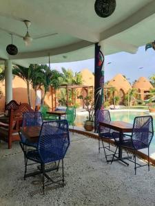 阿卡普尔科Wayahnb'al eco hostal的一个带桌椅的庭院和一个游泳池