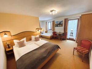 贝希特斯加登伽斯特豪斯宾馆的酒店客房设有一张大床和一张桌子。
