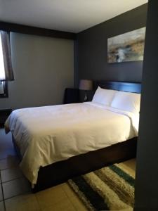 梅迪辛哈特梅迪辛哈特公园巷汽车旅馆的卧室配有一张带白色床单和枕头的大床。