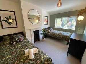 灵伍德Tipsy Cottage & Games Cabin with fire-pit and BBQ的一间卧室配有两张床和镜子