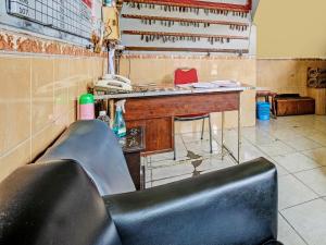 三宝垄SPOT ON 91912 Hotel Citra Dewi 2的一张黑椅子,放在带桌子的房间