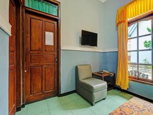三宝垄SPOT ON 91912 Hotel Citra Dewi 2的一间设有椅子、门和电视的房间