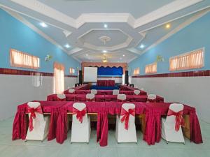 三宝垄Collection O 91914 Hotel Citra Dewi 2 Int's的宴会厅配有红色桌子和白色椅子