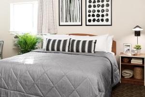 汉普顿Intown Suites Extended Stay Select Hampton VA的卧室配有带灰色棉被的床