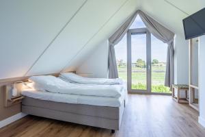 诺德韦克Duyndomein Noordwijk的一间卧室设有一张床和一个大窗户