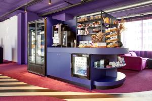 莱顿Hotel VIC的一间有紫色墙壁和有食物的货架的商店