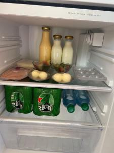 伊瓦格Glamping Akaya的装满瓶子和牛奶罐子的冰箱