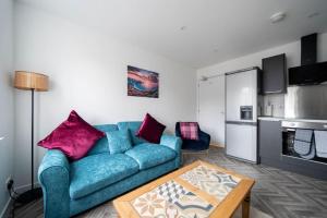 阿伯丁Links Loft -2 bed apartment minutes from Aberdeen beach的客厅配有蓝色的沙发和桌子