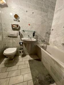 安娜贝格-布赫霍尔茨瓦德施罗森公园酒店的浴室配有卫生间、盥洗盆和浴缸。