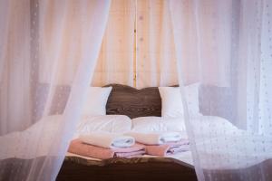高塔特拉山Vila Kotlina - High Tatras 2023的一张带白色窗帘和毛巾的床